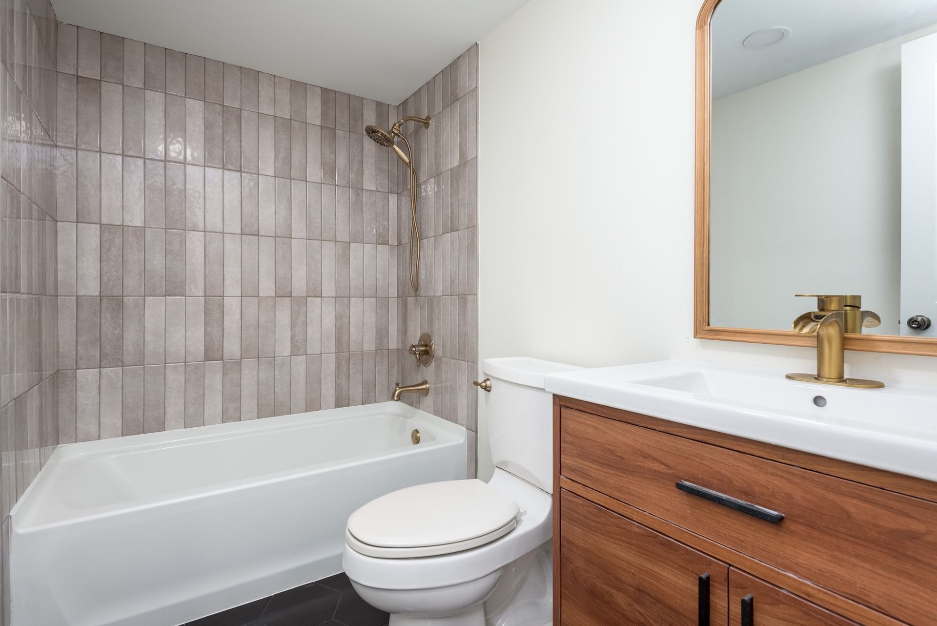 A bathroom with a toilet , sink , bathtub and mirror.