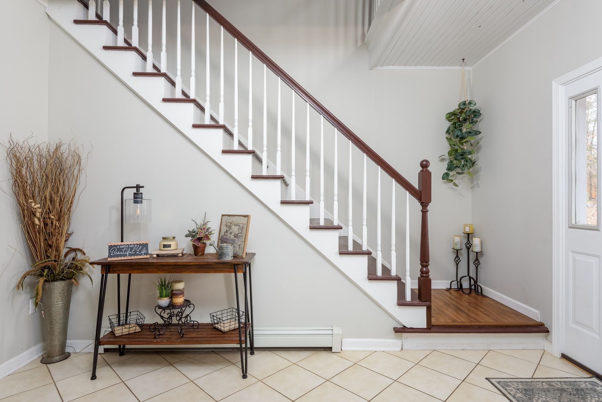 A hallway with a staircase and a table with candles on it