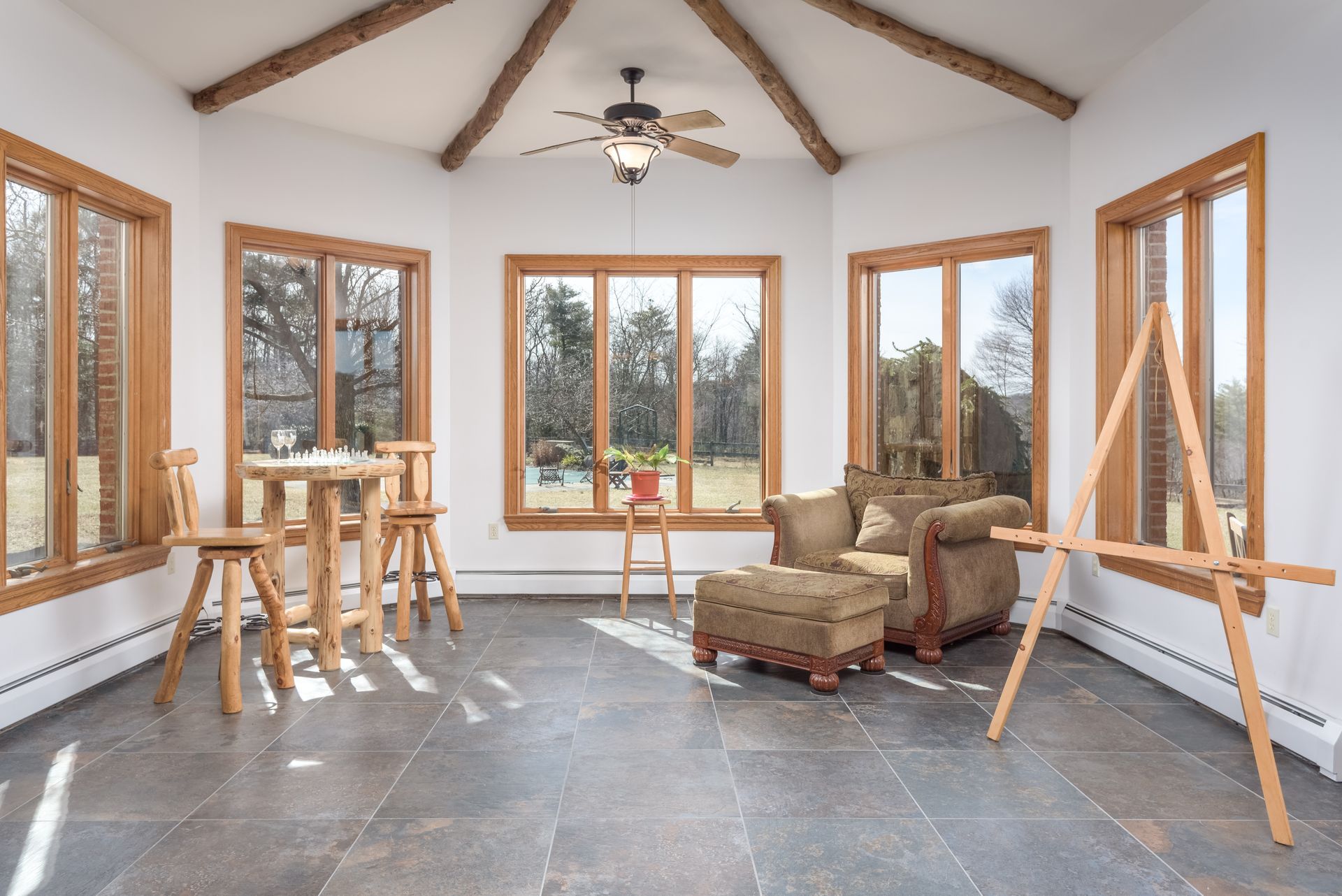 A living room with a lot of windows and a ceiling fan
