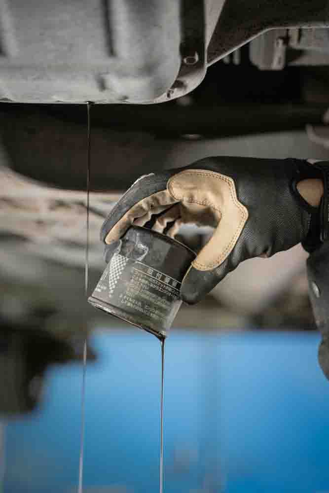 automotive oil pouring out of the engine with an oil filter