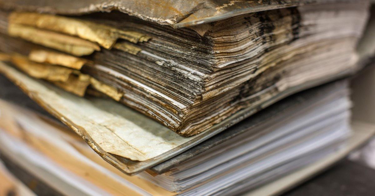 A stack of old papers sitting on top of each other on a table.