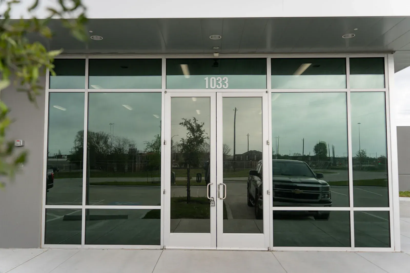 A car is parked in front of a building with a lot of windows.