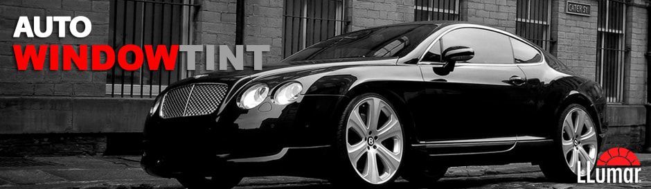 A black car is parked in front of a building.