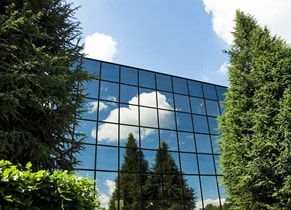 A large building with a lot of windows and trees in front of it.