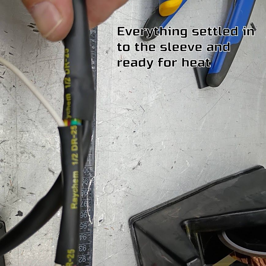 Electrical cable being heat-shrunk, with text noting everything is sealed in the sleeve and ready for heat.