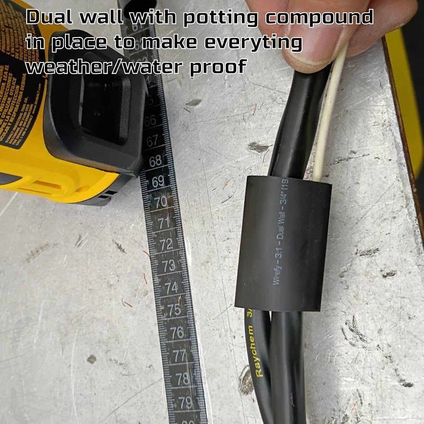 Black dual-wall heat-shrink tubing with potting compound on a cable, shown beside a measuring tape.