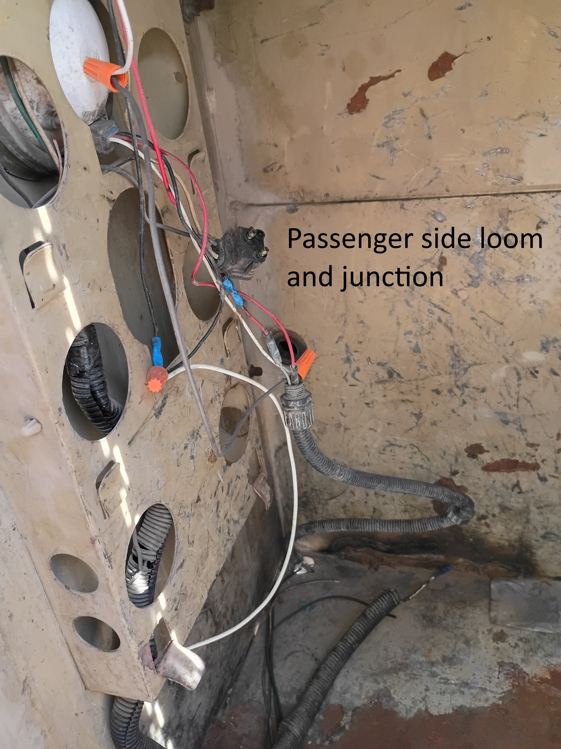Passenger-side loom and junction with exposed wires in a dusty interior panel