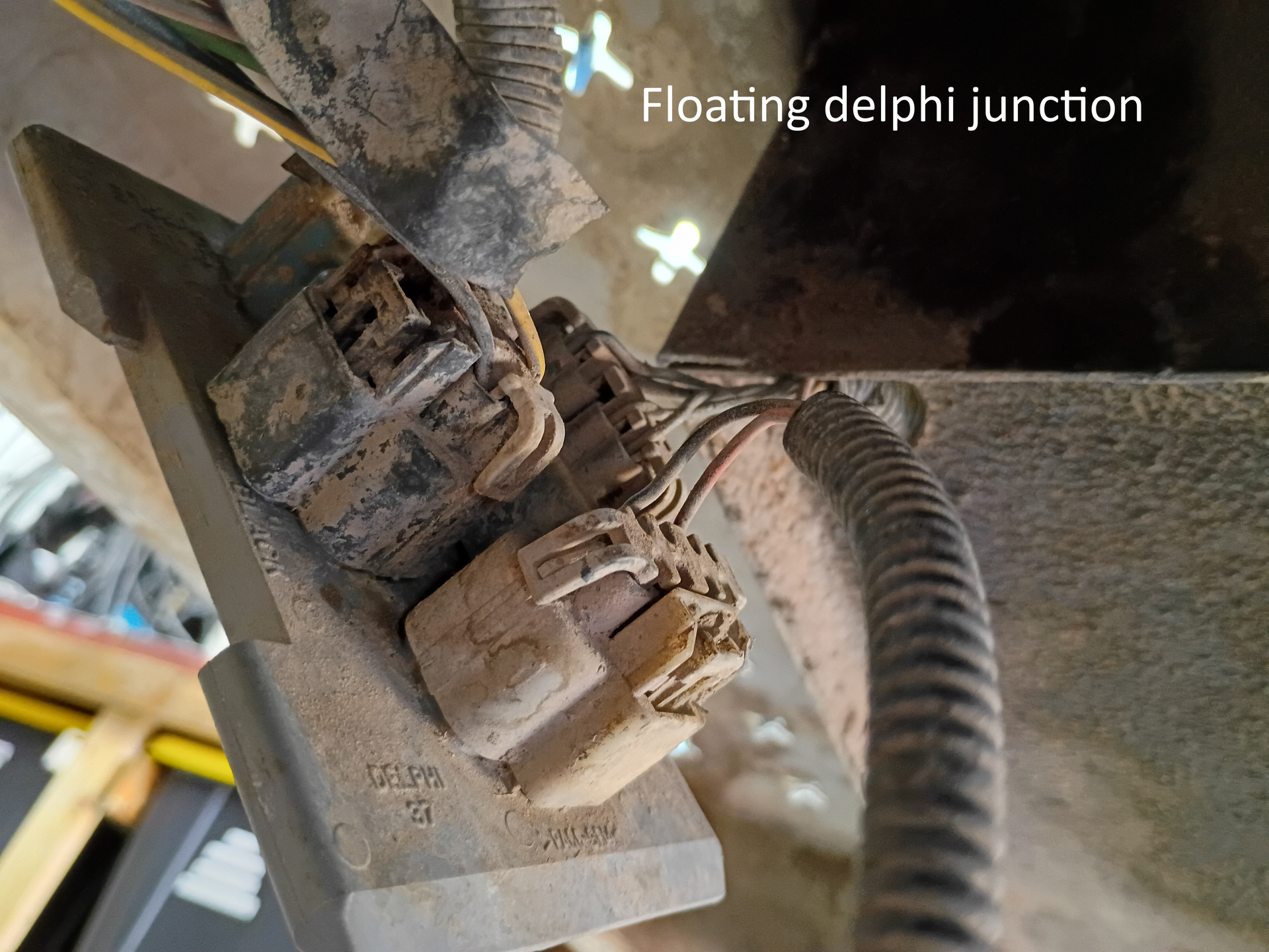Close-up of a dusty electrical connector and wiring on machinery, with a label reading “flecting delphi junction”