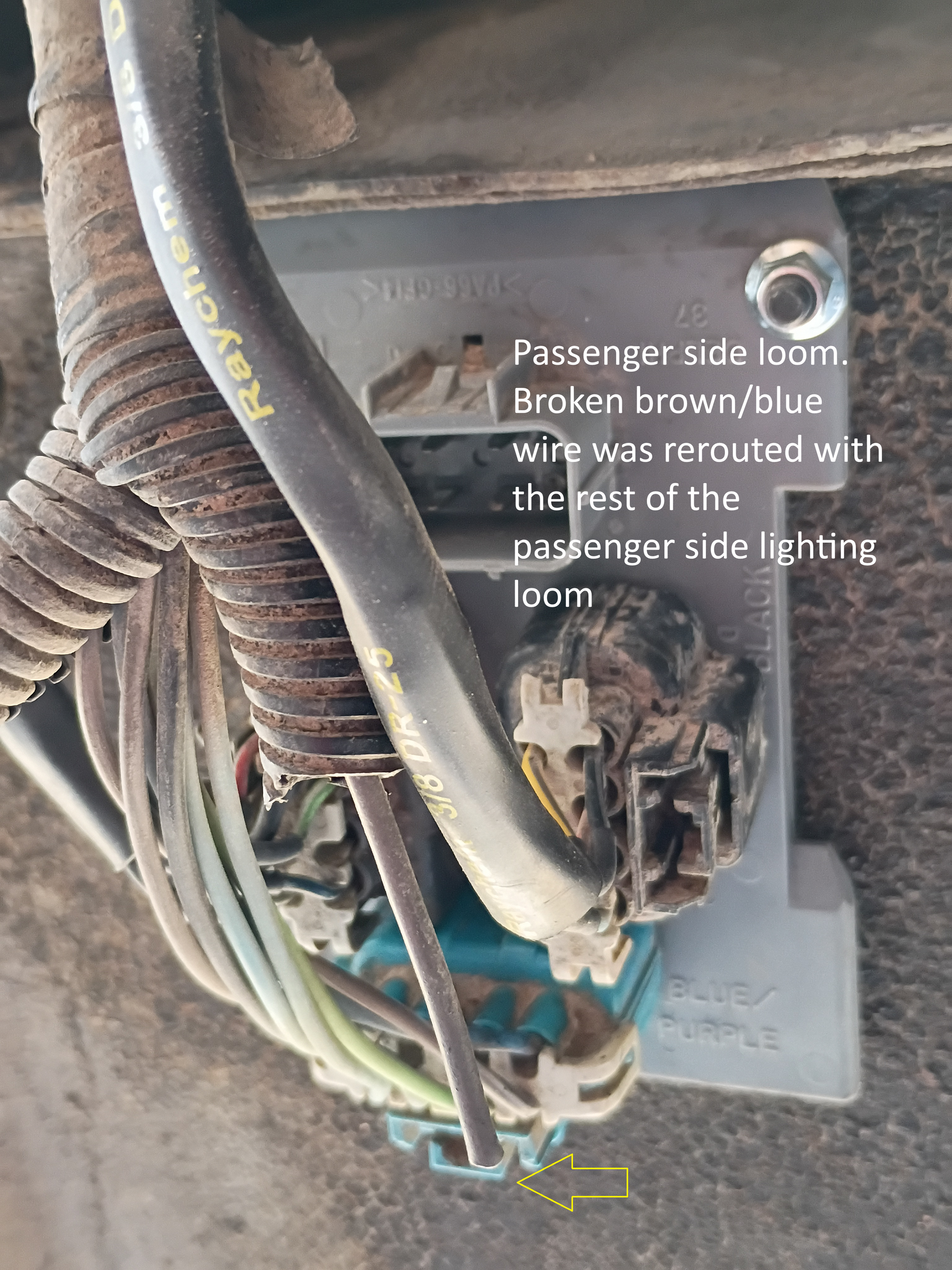 Broken trailer-side wiring harness with exposed wires and loose connectors under a vehicle frame.