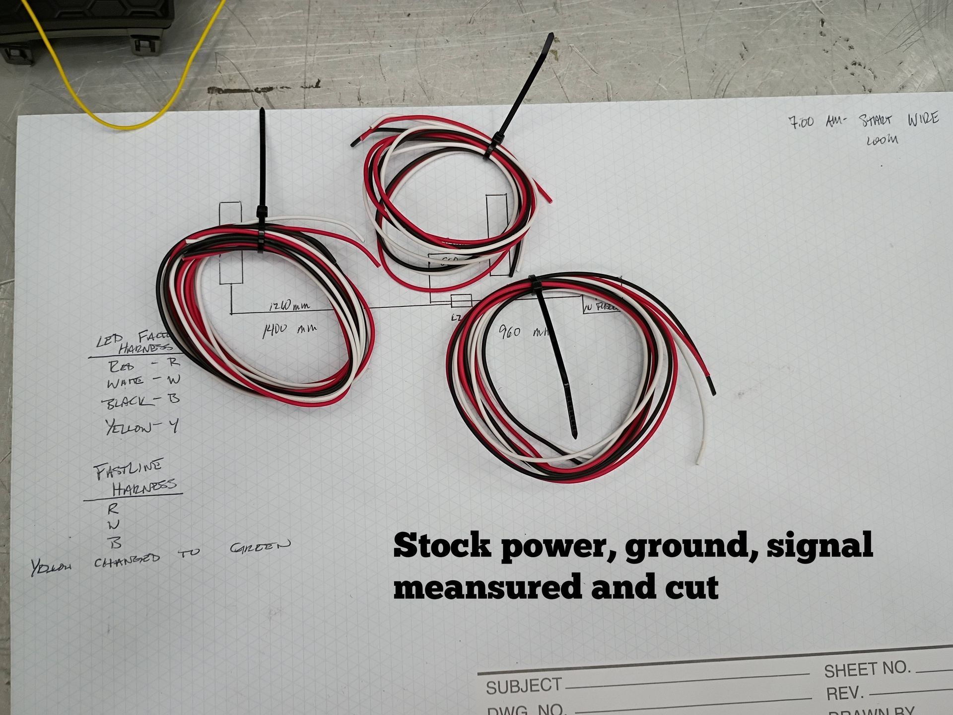 Three coiled red-and-black wires on paper labeled “Stock power, ground, signal measured and cut”