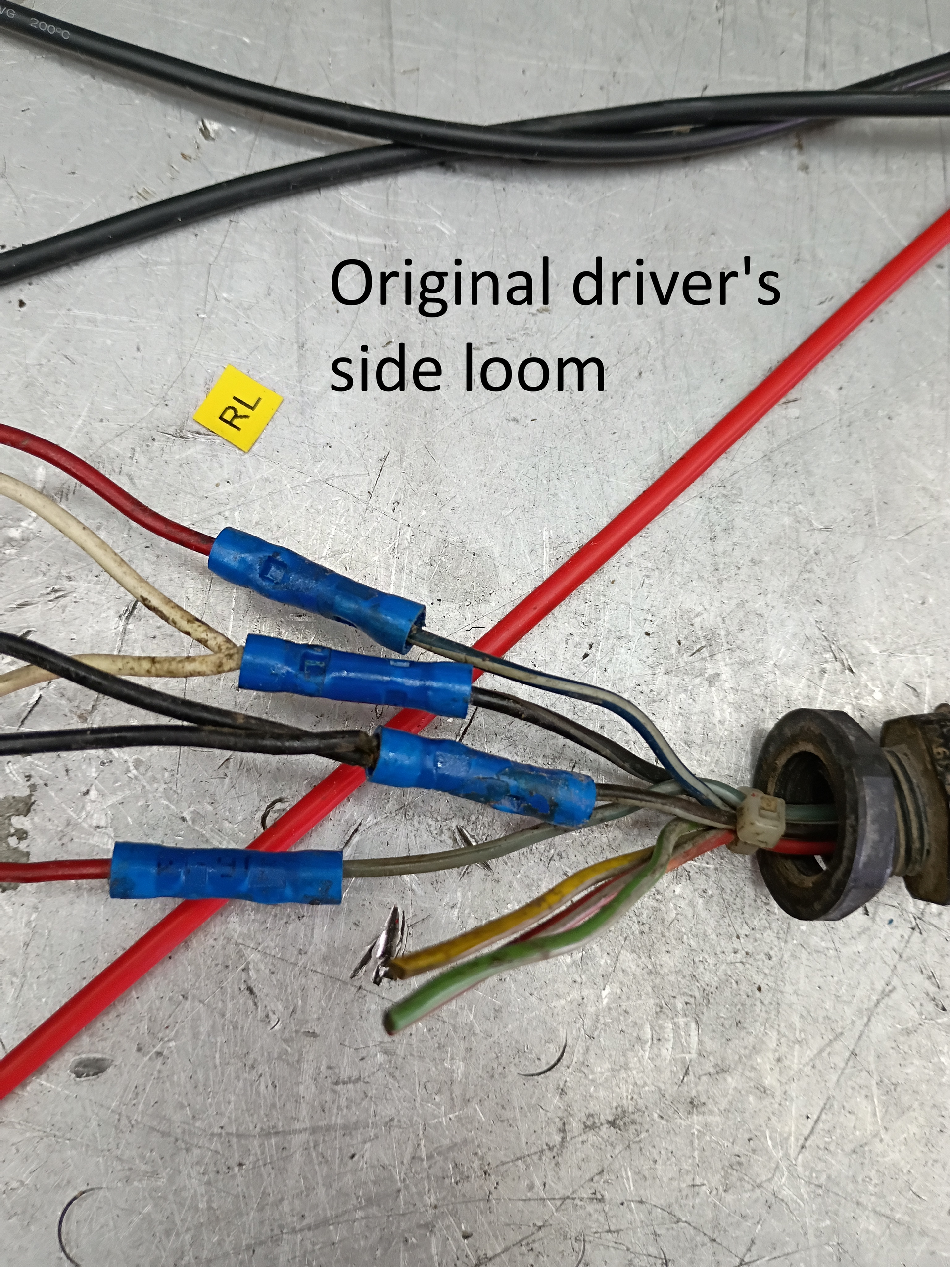 Wiring loom labeled “Original driver’s side loom” with blue connectors on a work surface