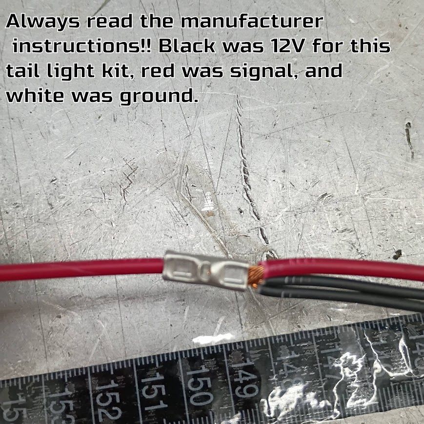 Wires spliced with a crimp connector on a gray surface, with text noting red is signal and white is ground.
