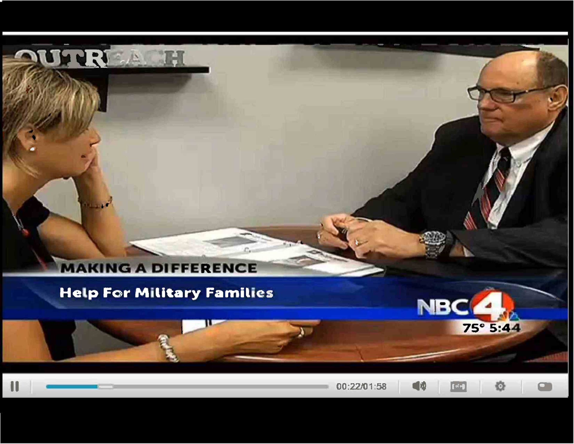 A man in a suit and tie is talking to a woman at a table
