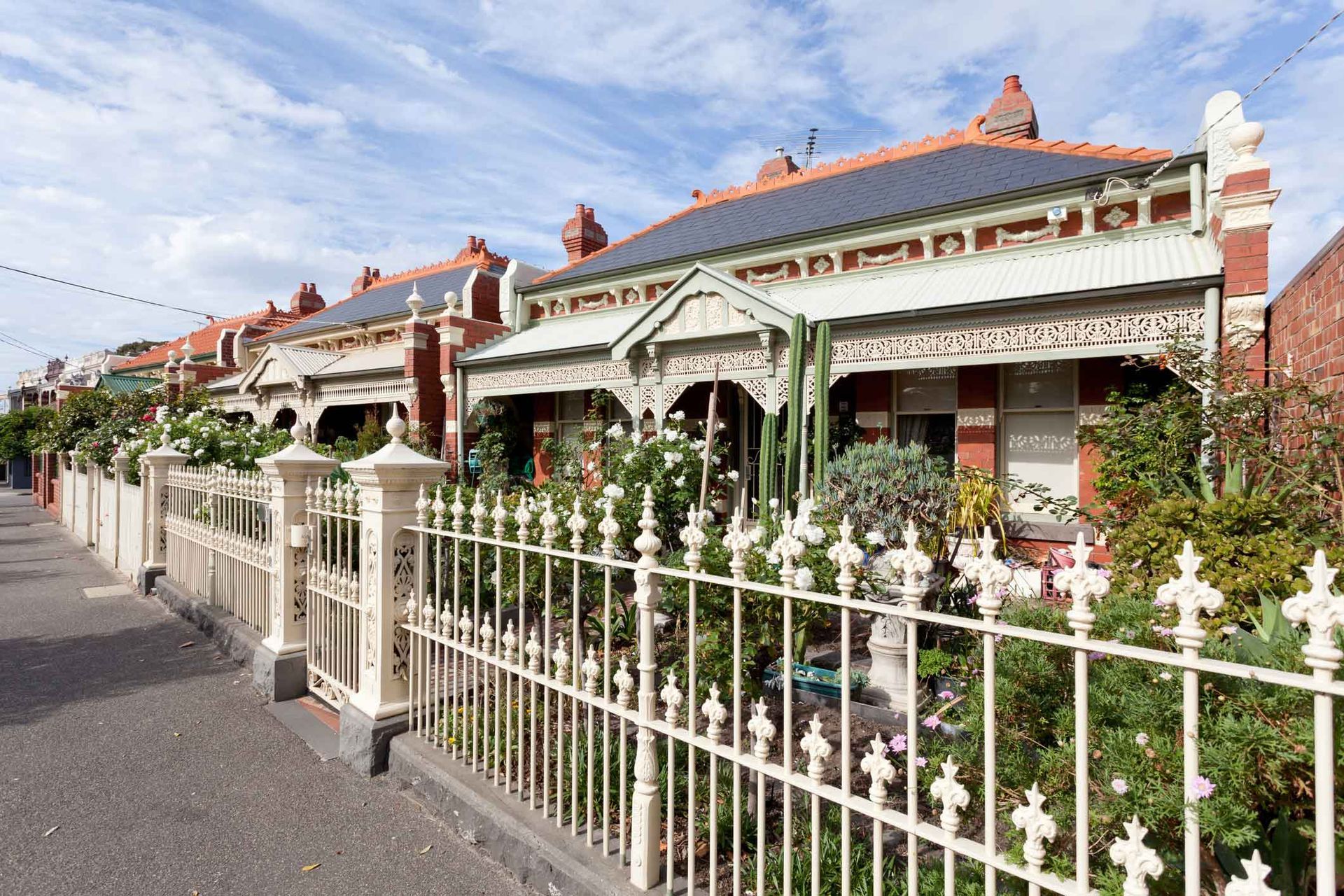A row of houses with a white fence in front of them.