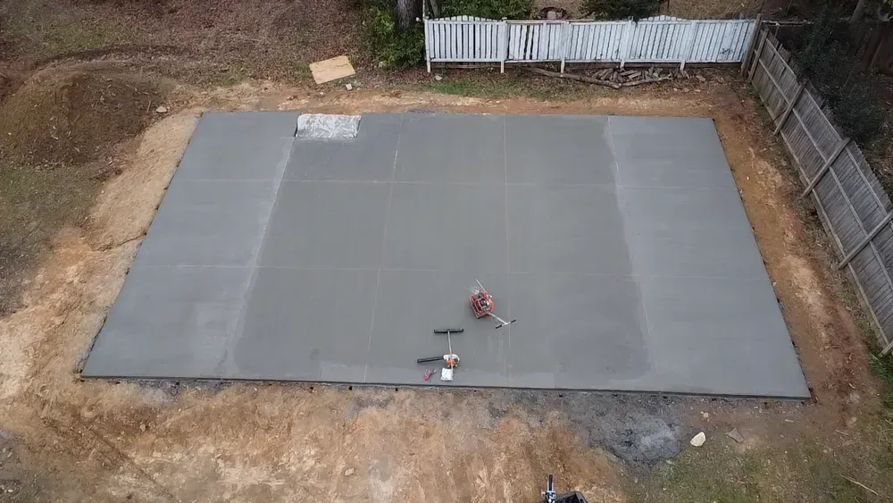 An aerial view of a concrete floor in a backyard.