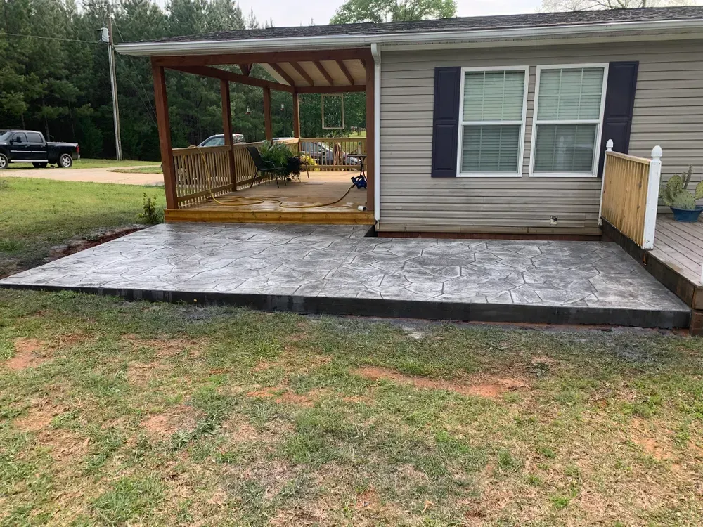 A mobile home with a concrete patio in front of it.