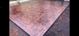A man is working on a patio in front of a house.