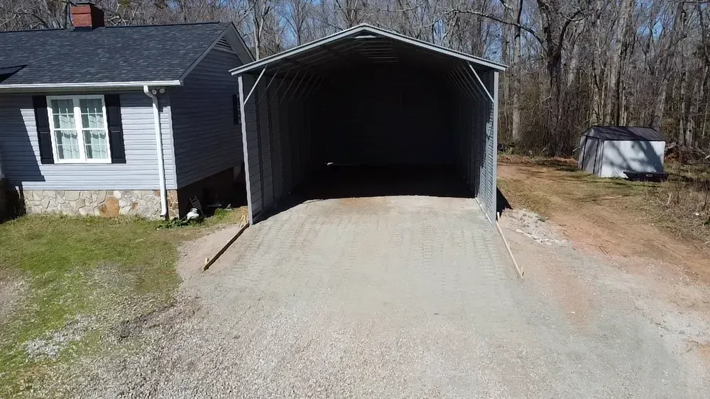 There is a carport in the driveway of a house.