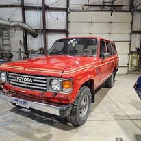 Red Toyota SUV parked inside a garage, front-left view.