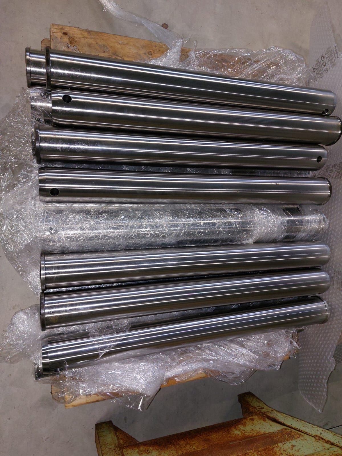 un mucchio di aste metalliche sono impilate una sopra l'altra su un tavolo di legno.