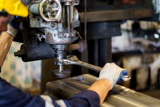 un uomo sta lavorando su una macchina in una fabbrica.