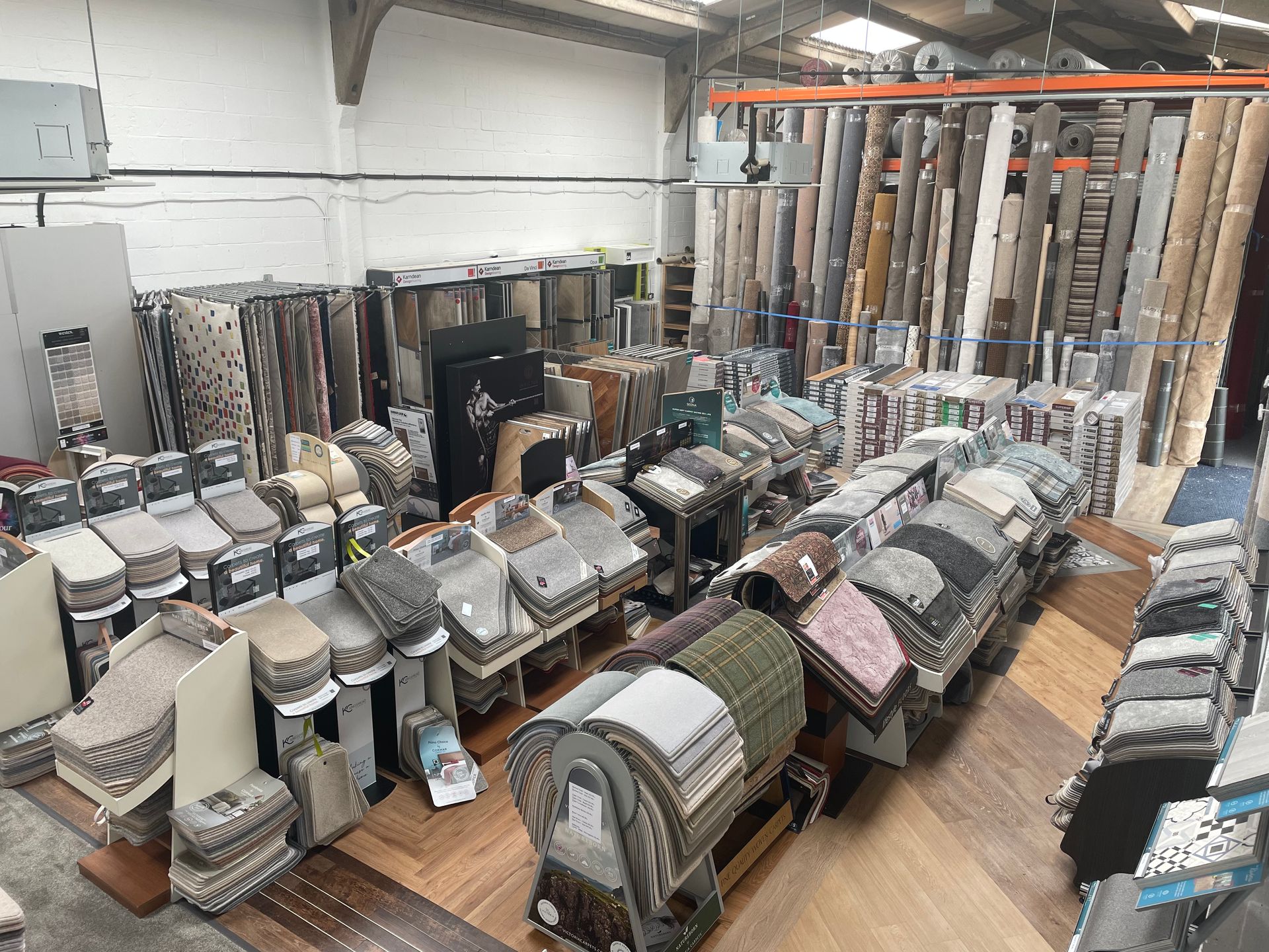 a warehouse filled with a variety of carpets and flooring