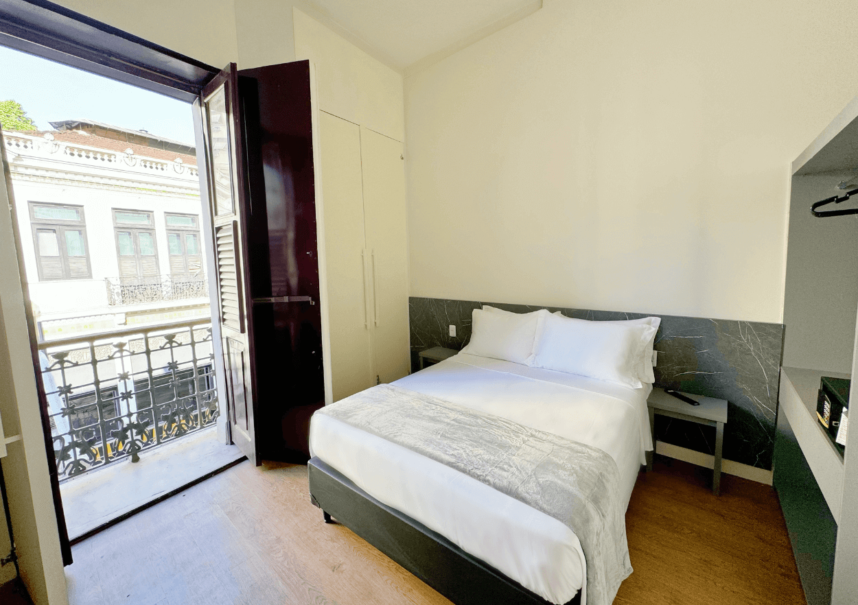 Um quarto de hotel com uma cama king size e uma varanda.