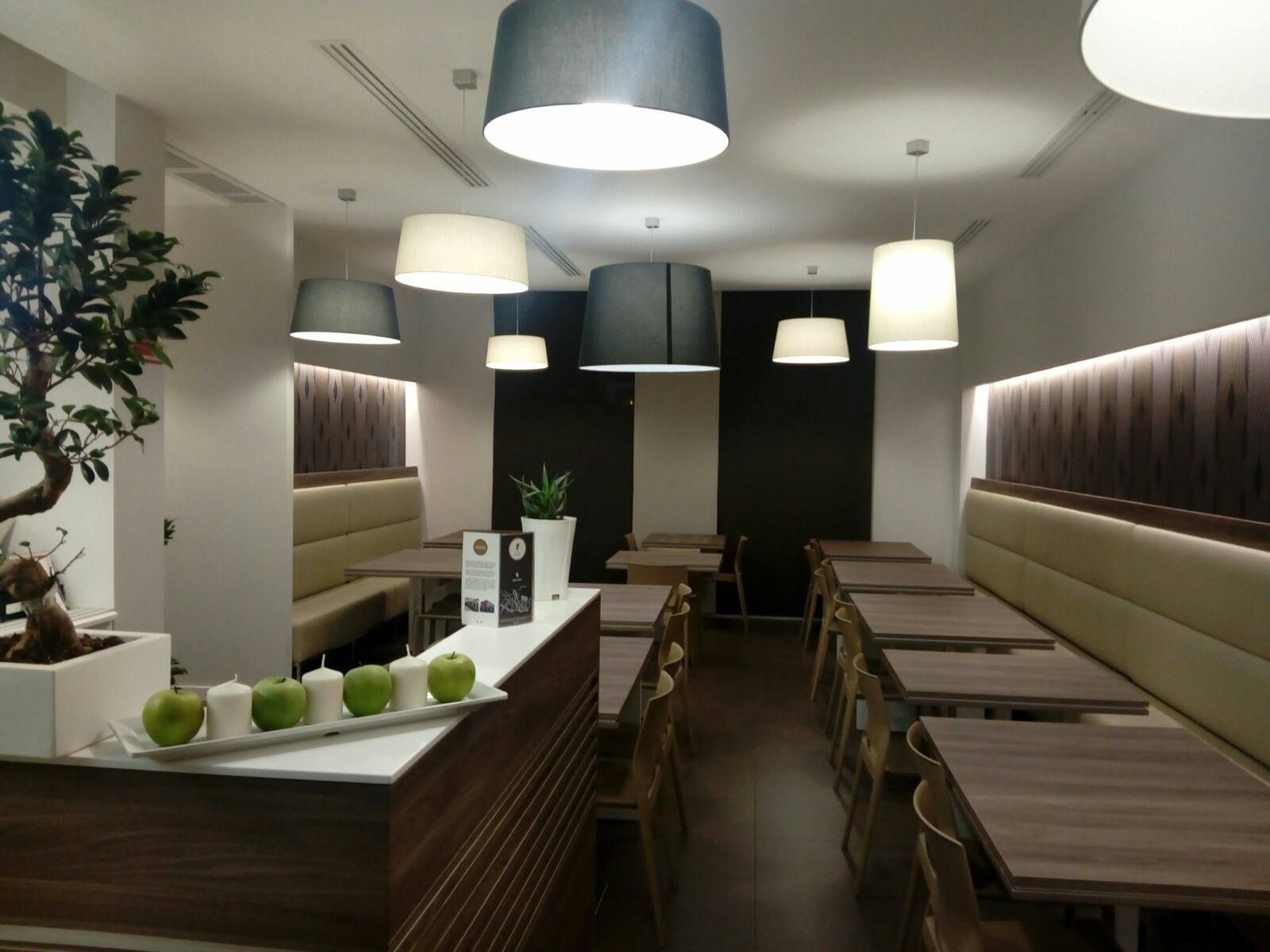 Un ristorante con tavoli e sedie e un vassoio di mele