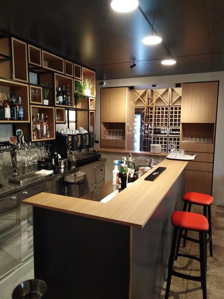 Una cucina con un bar e due sgabelli rossi