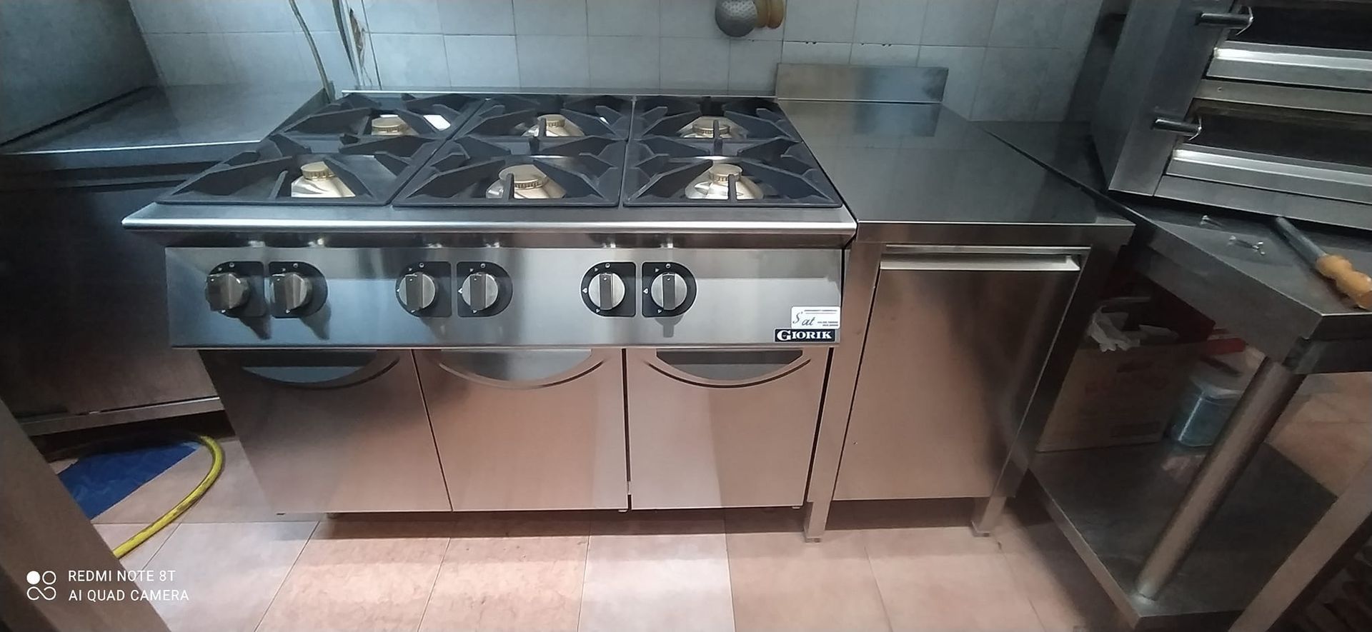 In cucina c'è un fornello in acciaio inox con quattro fuochi.