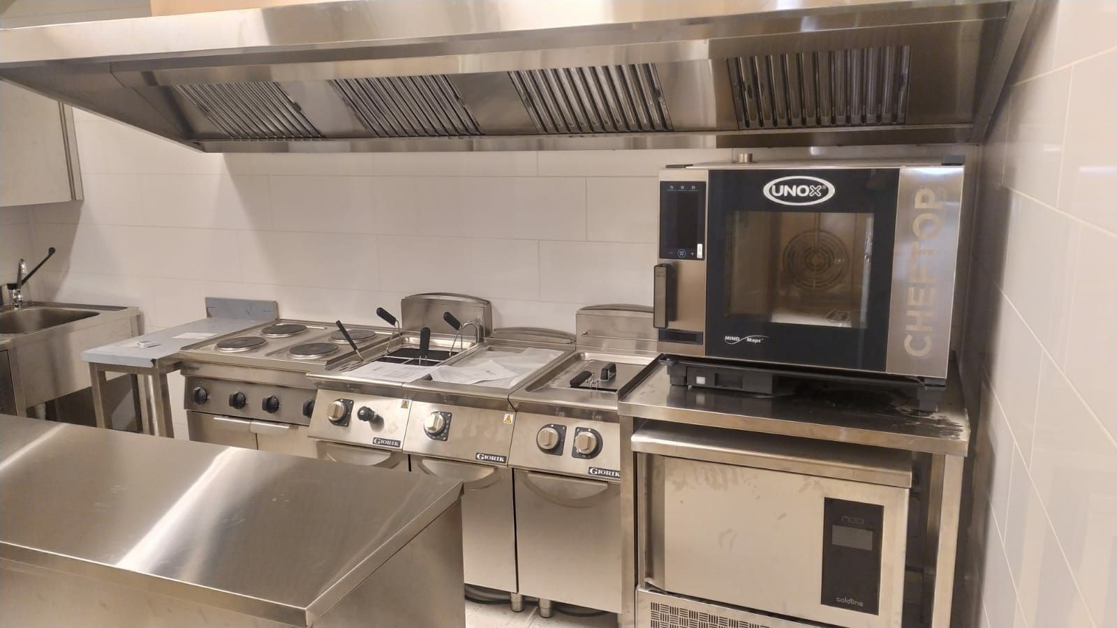 Una cucina con elettrodomestici in acciaio inossidabile e un forno a microonde.
