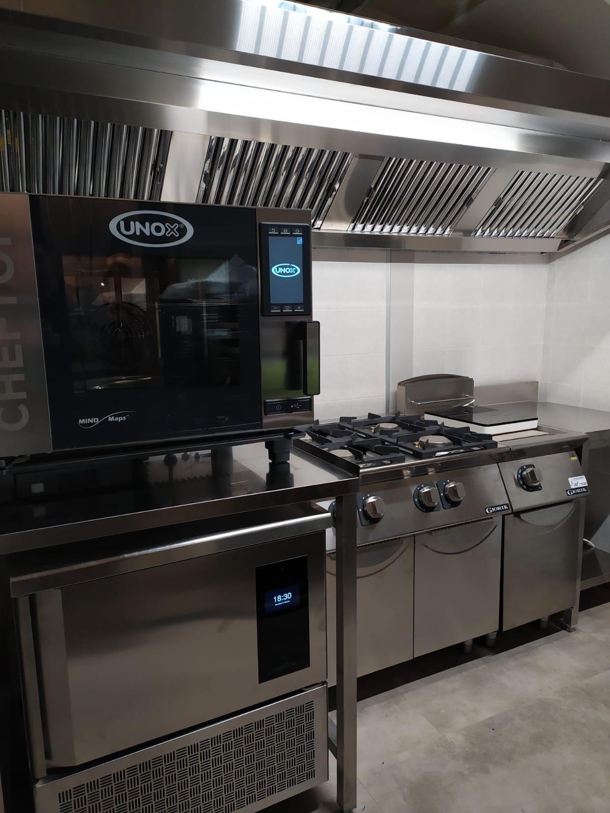 Una cucina con elettrodomestici in acciaio inossidabile e fornelli.