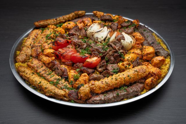 A large plate of food with meat and vegetables on a table.