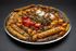 A large plate of food with meat and vegetables on a table.