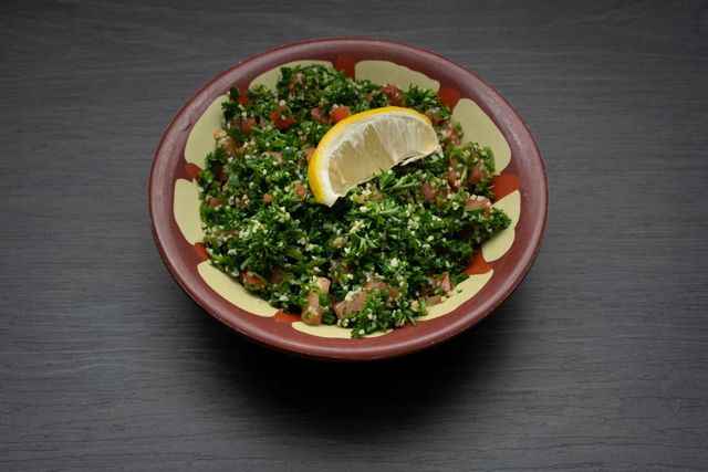 A bowl of food with a slice of lemon on top.