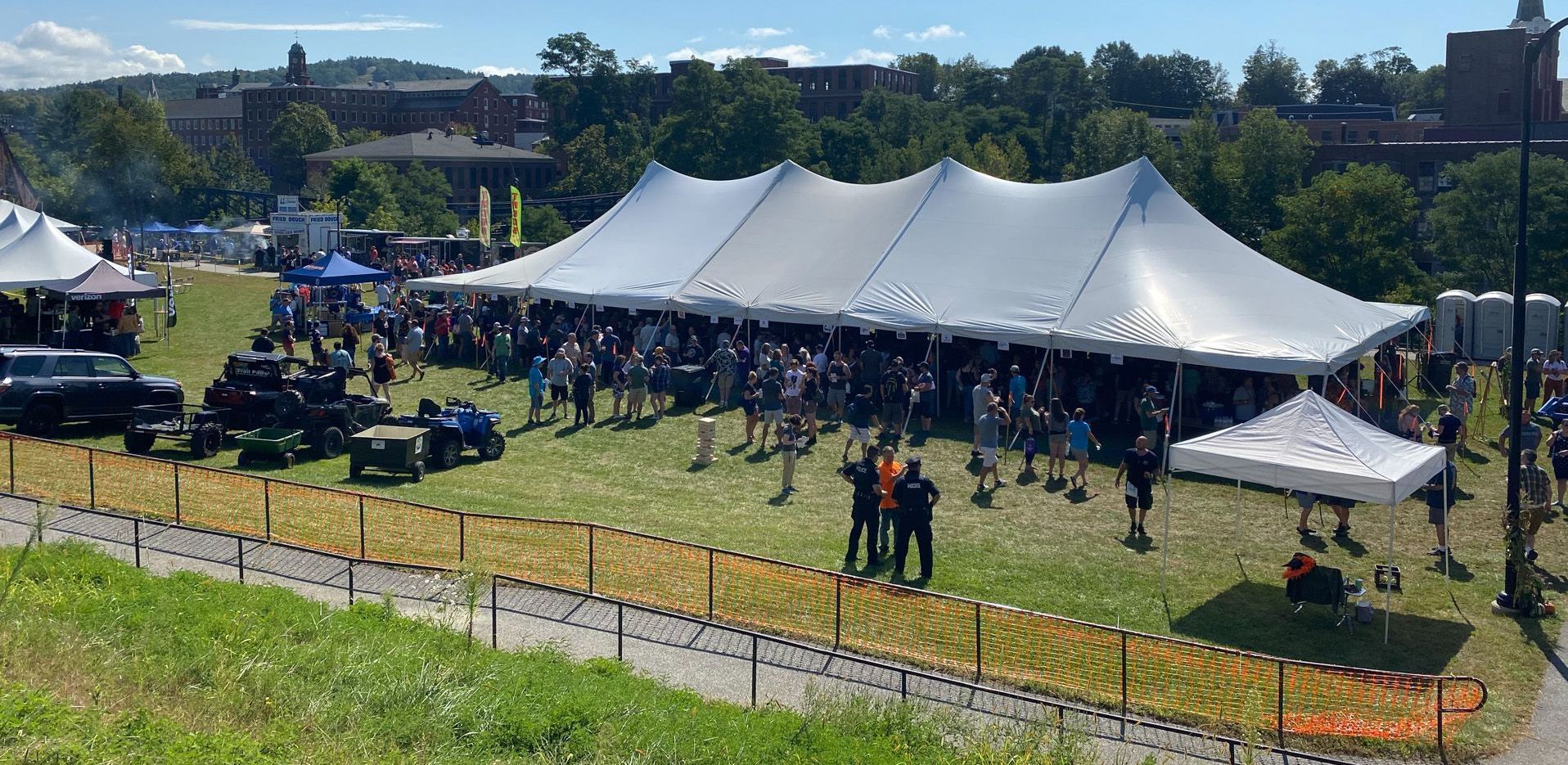 A large white tent is sitting in the middle of a grassy field.