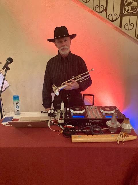A man in a cowboy hat is playing a trumpet