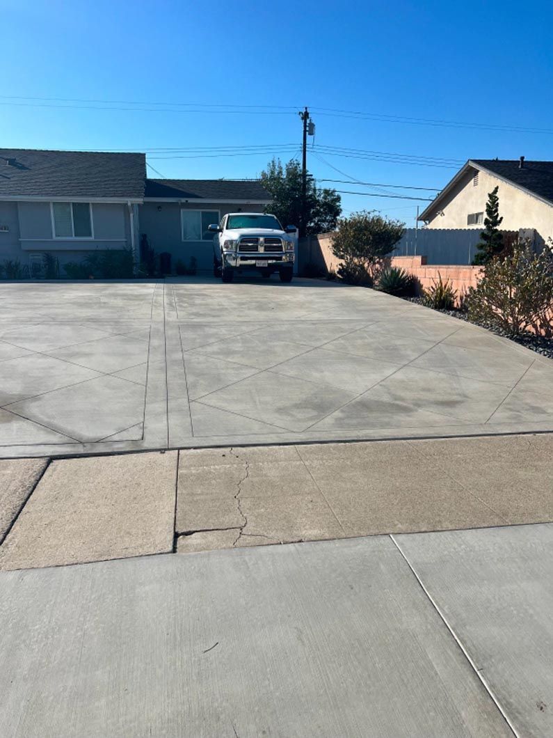A truck is parked in a driveway in front of a house.