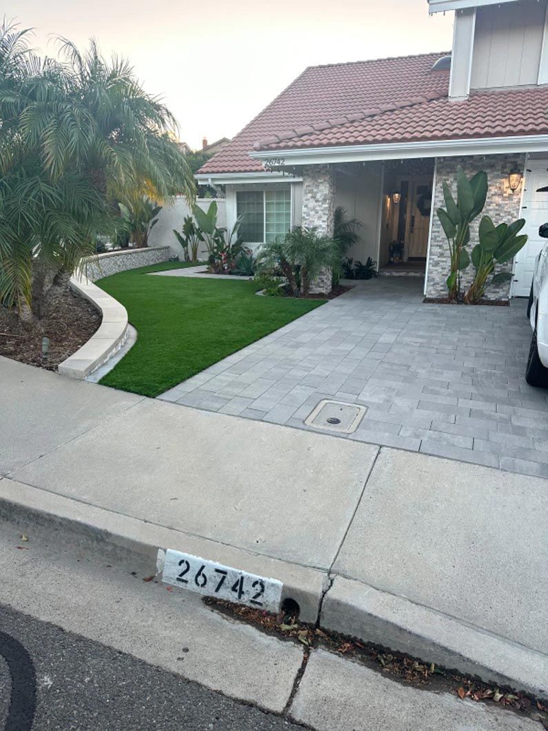 A white car is parked in front of a house.