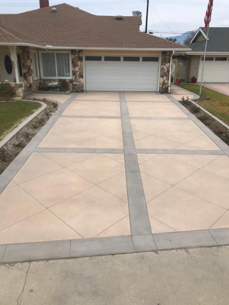 A driveway leading to a house with a garage door.