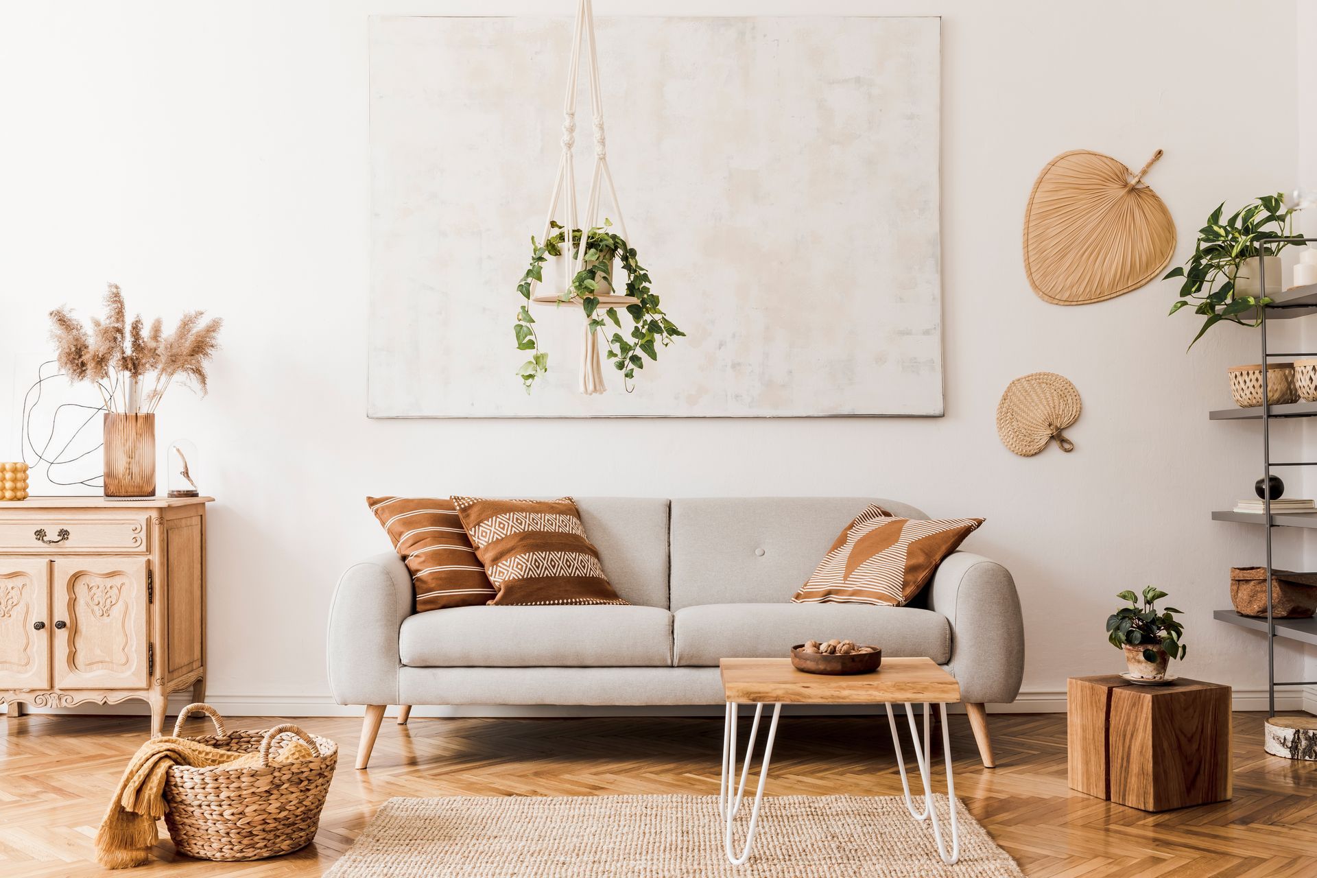 A living room with a couch , coffee table , and a painting on the wall.