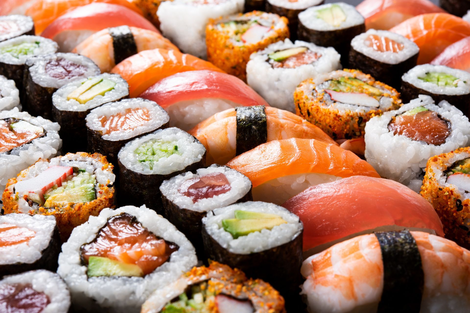 Assorted sushi rolls and nigiri arranged in a close-up buffet display