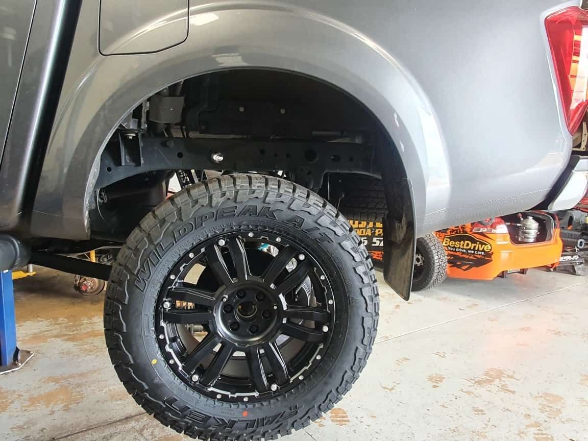 A Truck With Black Wheels And Tires Is Sitting On A Lift In A Garage — Suncoast Mechanical In Nambour, QLD