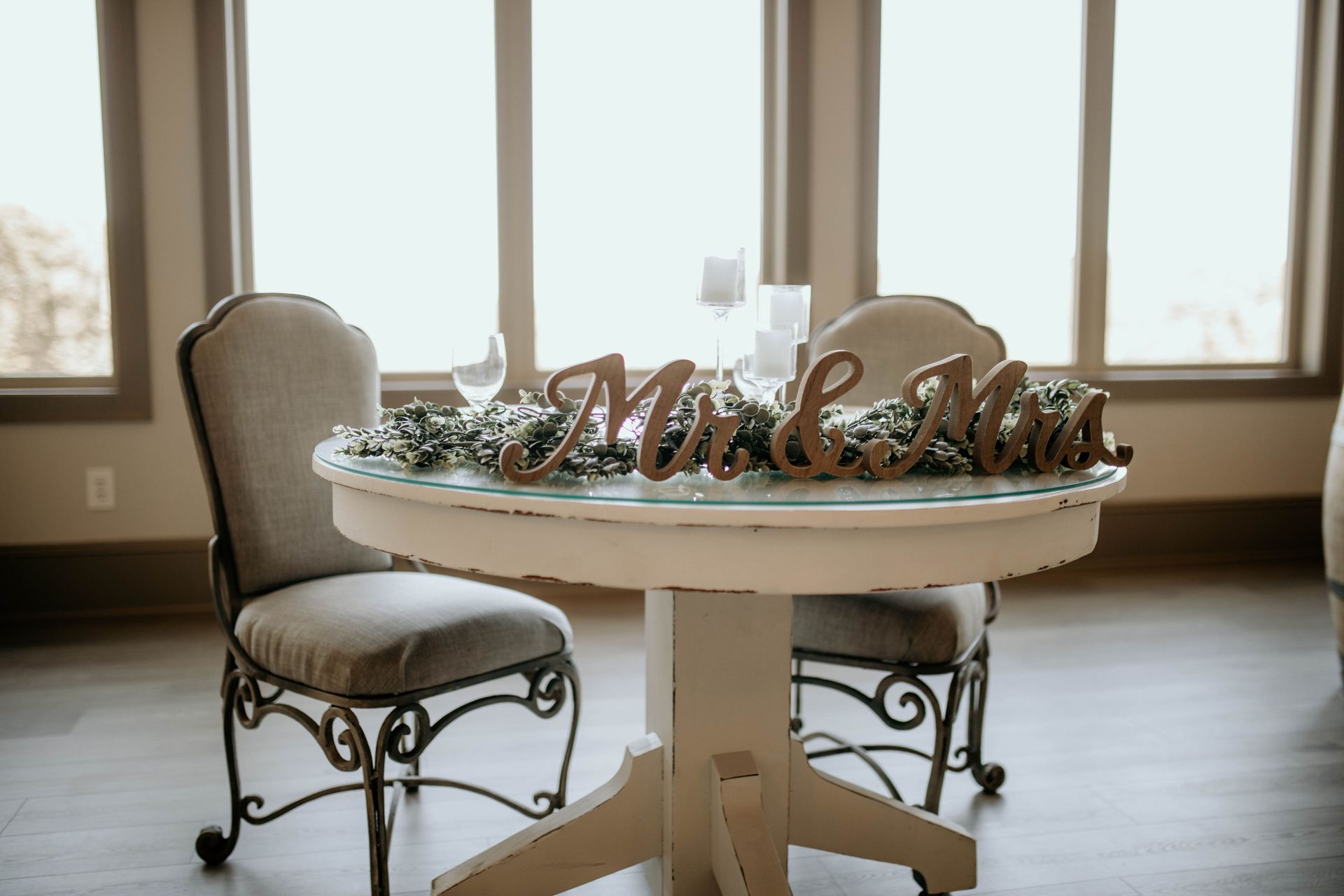 A table with two chairs and a sign that says mr. and mrs.