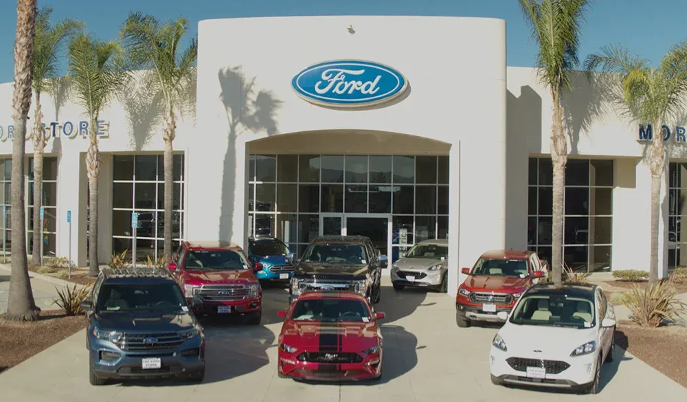 Ford dealership exterior with multiple Ford vehicles parked in front.