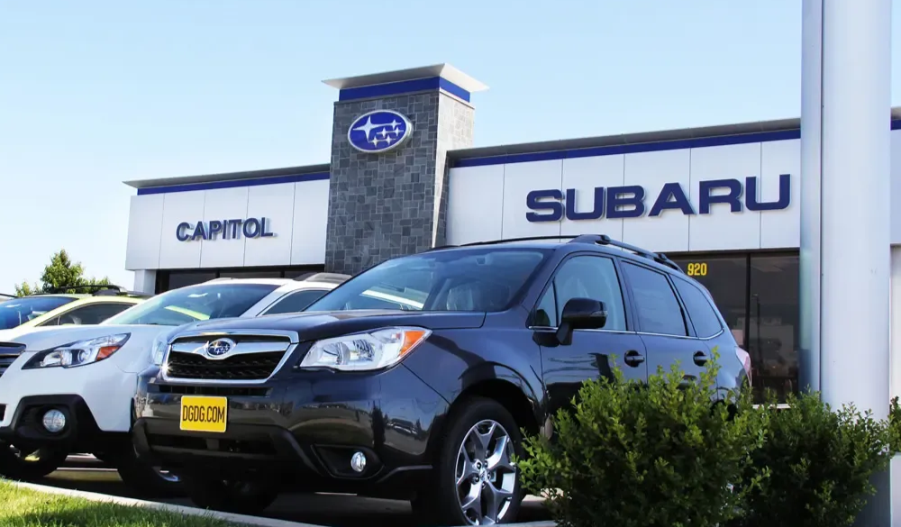 Subaru dealership with parked cars. Building has