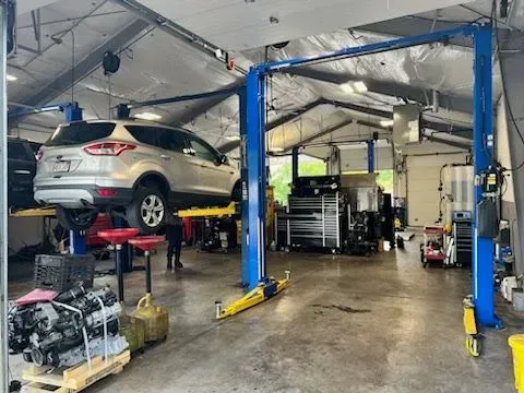 Fiore's Automotive Garage with SUV Raised on Blue Lift | Fiore's Automotive