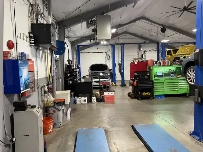 Inside The Auto Shop with Gray Car Sits Between Lifts | Fiore's Automotive