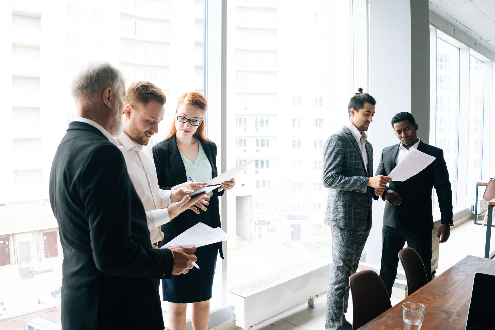 Business professionals discussing documents in a bright office conference room