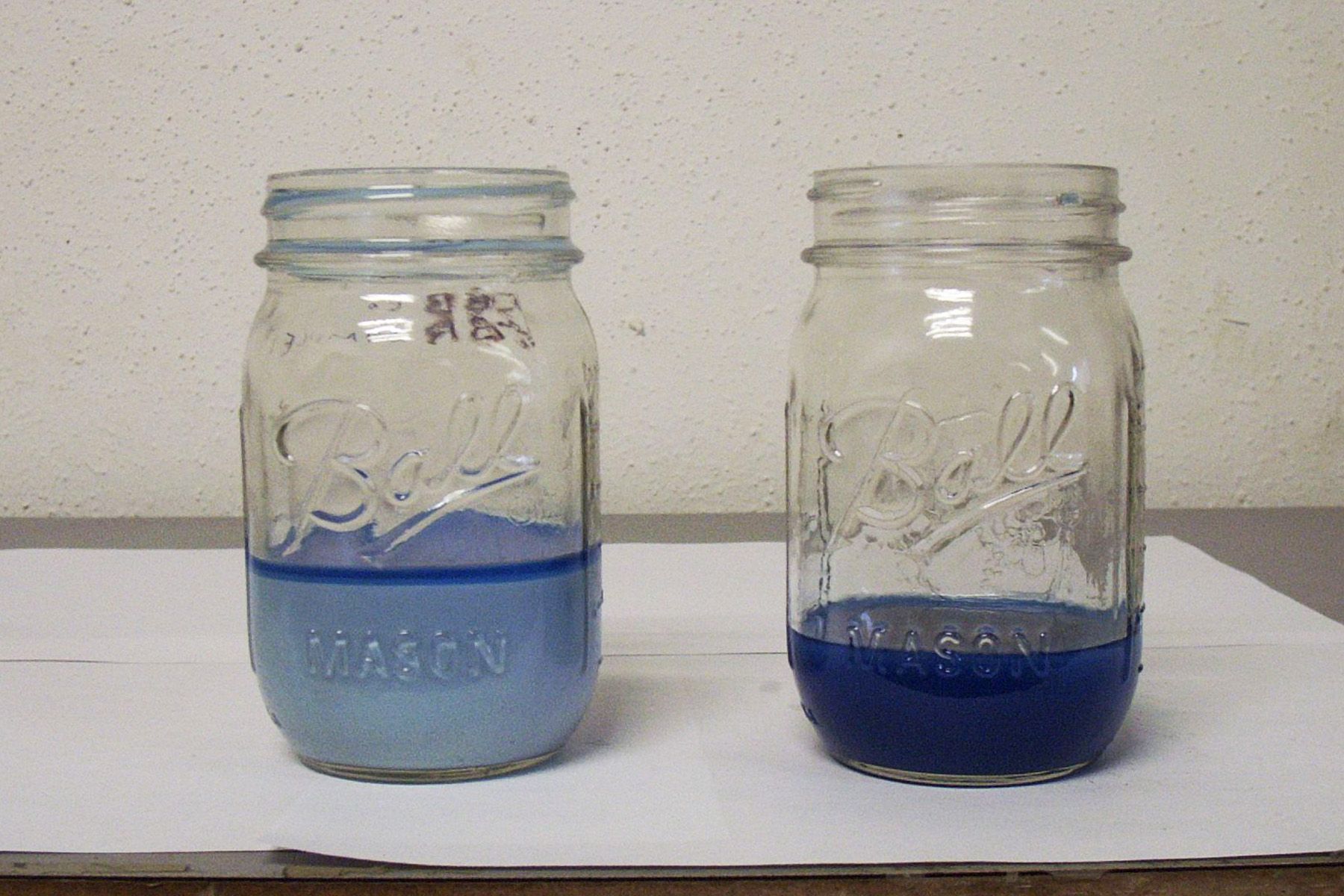 Two ball mason jars filled with blue liquid on a table